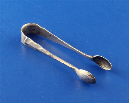 A pair of 1930s planished silver sugar tongs by Omar Ramsden, 25 grams.